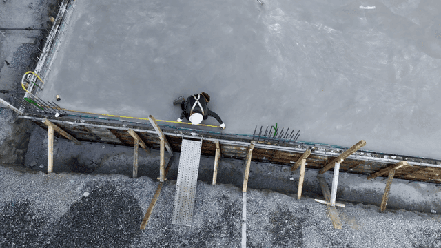 콘크리트 표면을 측정하는 작업자