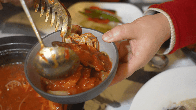 Scene of putting spicy seafood stew in bowl