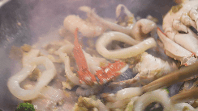 Seafood being stir-fried in a pan