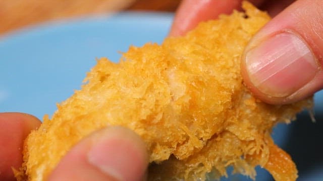 Crispy fried boneless chicken being torn apart