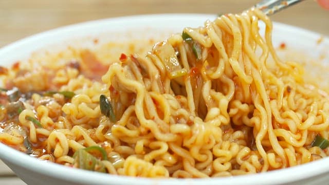 A bowl of spicy Korean ramen with vegetables