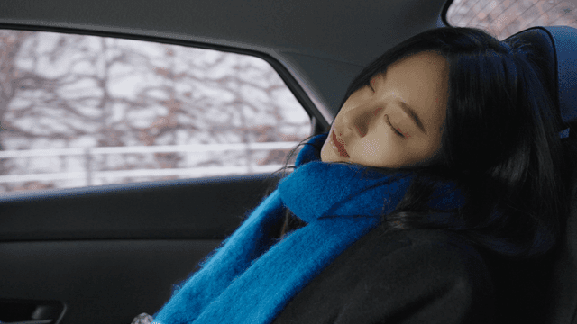 Side view of a woman sleeping in the backseat of a taxi