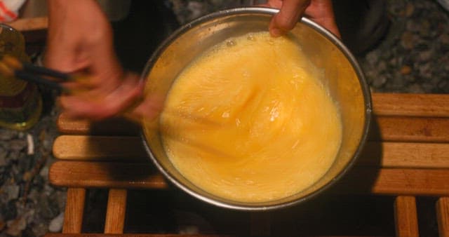 캠핑장에서 그릇에 달걀 풀기