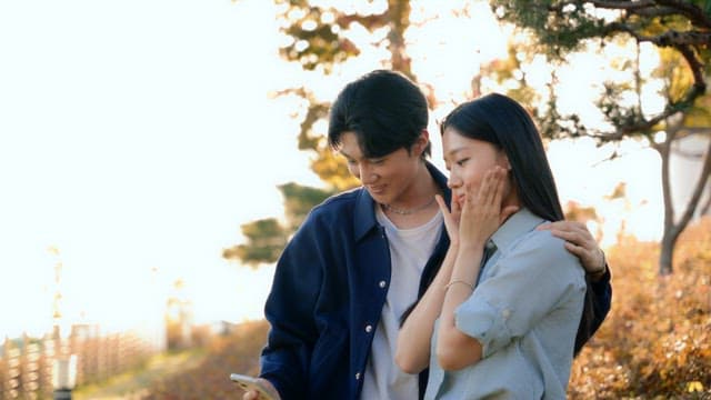 공원에서 찍은 셀카를 확인하는 커플