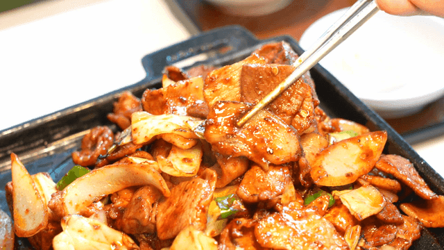 Spicy stir-fried pork picked up with chopsticks