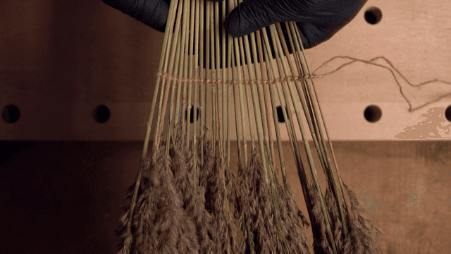 손으로 갈대를 끈으로 묶는 모습