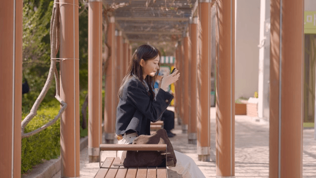 공원 벤치에 앉아 거울을 보는 여성