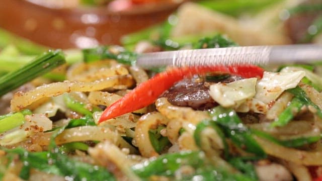 Chopstick of stir-fried white sundae with noodles and vegetables