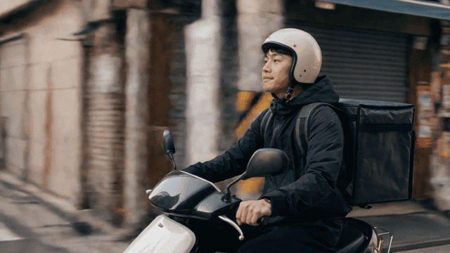 도로에서 스쿠터를 타는 배달원