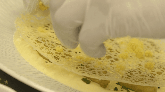 Chef's hands plating flour on gnocchi