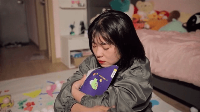 방에서 일기장을 안고 우는 여성