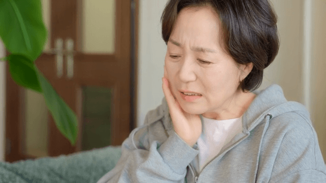 실내에서 치통을 겪는 여성