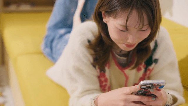 스마트폰을 사용하며 웃고 있는 여성