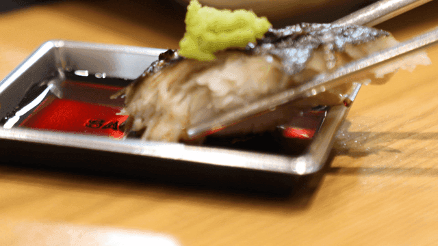 Grilled fish topped with wasabi, dipped in soy sauce