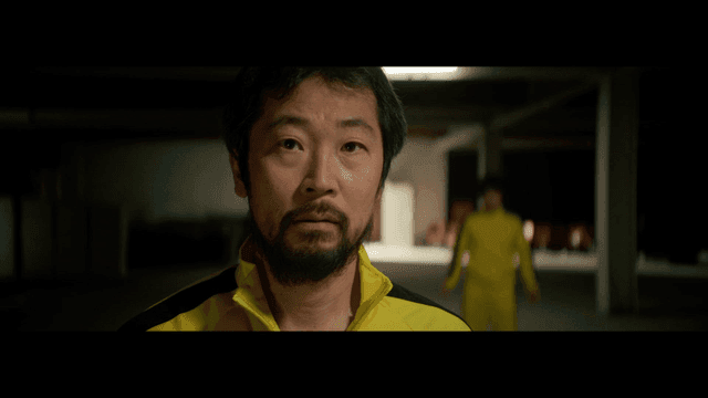 실내에서 노란 트랙수트를 입은 남자