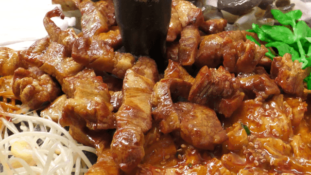 Pork belly with mushrooms and vegetables in cauldron lid