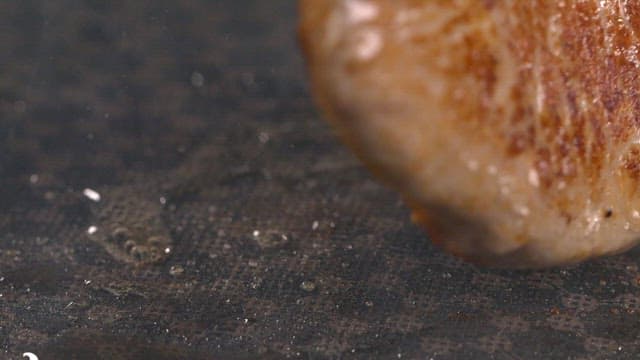 그릴 위에서 지글거리는 고기 한 조각